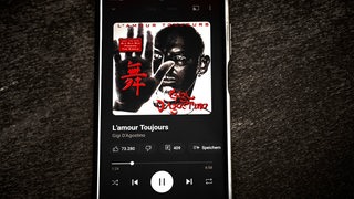 Ein Smartphone, auf dem "L'amour Toujours" 