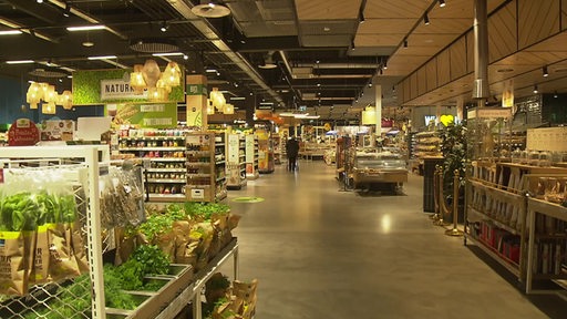Es sind mehrere Regale mit Lebensmitteln in einem Supermarkt zu sehen.