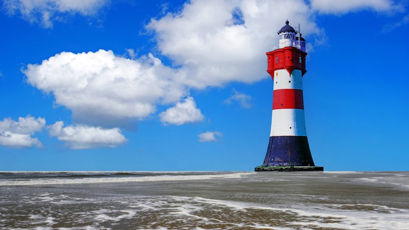 In der Wesermündung steht der Leuchtturm Roter Sand im Watt.