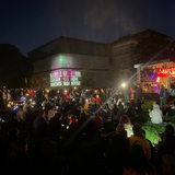 Auf der Fassade der Kunsthalle in Bremen ist der Schriftzug "Lichter gegen Rechts!" zu lesen. Im Vordergrund sitzen Menschen auf einer Wiese und schauen auf eine Bühne.