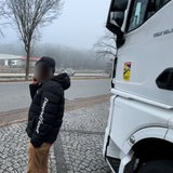 Ein Mann steht neben einem LKW. Sein Gesicht ist verpixelt