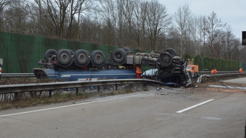 Ein Lkw liegt umgekippt auf der Autobahn.