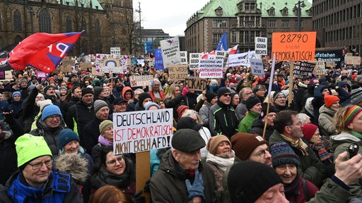 Mit selbstgemachten Schildern und Plakaten demonstrieren viele Menschen auf dem Marktplatz vor der Bürgerschaft gegen Rechtsextremisus.