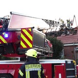 Feuerwehrleute löschen ein brennendes Wohnhaus