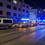 Vor einer Shisha-Bar stehen mehrere Polizeiautos.