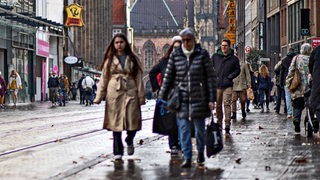 Menschen gehen bei herbstlichem Wetter durch die Obernstraße in Bremen