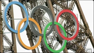 Die Olympischen Ringe befestigt am Pariser Eifelturm.