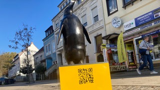 Eine Pinguin-Skulptur steht in Bremen-Gröpelingen auf einem Platz.