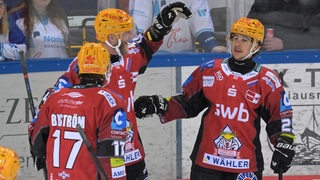 Spieler der Pinguins klatschen sich ab.