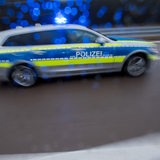 Ein Polizeiauto fährt auf einer Autobahn.