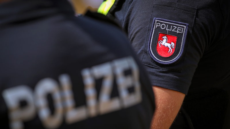 Polizisten mit Warnweste und Logo des Bundesland Niedersachsen im Einsatz