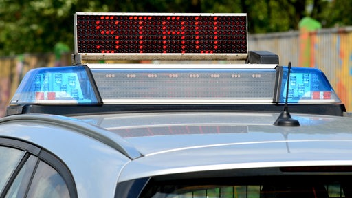 Auf einem Polizeiauto steht eine "Stau"-Leuchtschrift