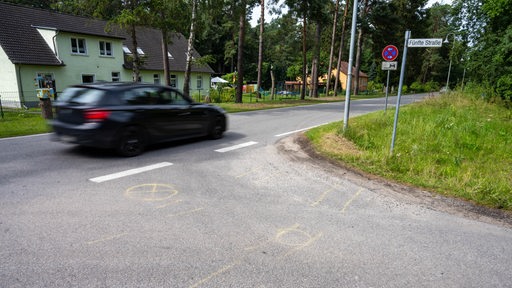 Auf einer Straße sind im Kreuzungsbereich Markierungen auf dem Boden zu sehen.