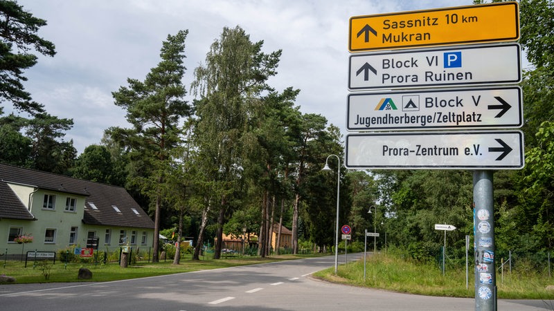 Straßenschilder stehen an einer Kreuzung, sie weisen unter anderem den Weg nach Sassnitz, Mukran und zu einer Jugendherberge.