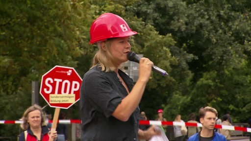 GEW Landesvorstandssprecherin Ramona Seeger mit Mikrofon bei der Protest Aktion.