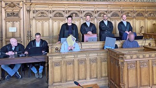 Bild zeigt die Anklagebank im Landgericht Bremen mit den 3 Angeklagten (Gesichter unkenntlich). Dahinter die Verteidigung
