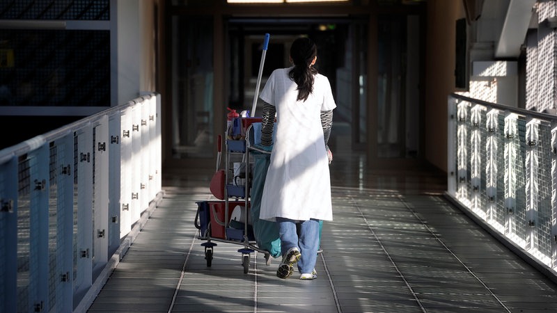 Eine Putzkraft läuft durch ein Krankenhaus.