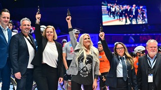 Bundesinnenministerin Nancy Faeser, Sängerin Natalie Horler und Feuerwehrfrau Yvonne Dommaschke schießen nebeneinander die 58. Bremer Sixdays an.