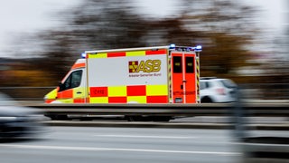 Ein Rettungswagen fährt zwischen anderen Autos auf der Autobahn.