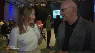 Die Reporterin Finja Böhling interviewt einen Mann auf dem Helferfest.