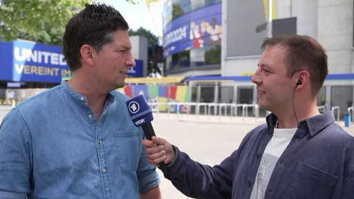 Der Sportblitz-Reporter Dino Bernabeo interviewt Tore Felgendreher vor dem Dortmunder Stadion.