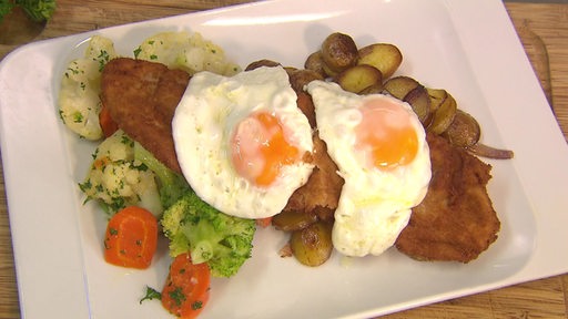 Das Gericht des dieswöchigen Bremer Tellers, Schnitzel mit Gemüse, Bratkartoffeln und Spiegeleier, ist auf einem Teller angerichtet