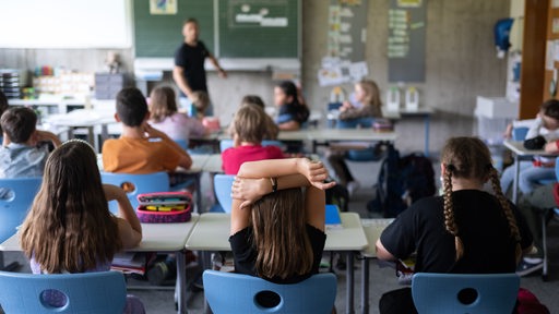 Schülerinnen und Schüler einer vierten Klasse einer Grundschule nehmen am Unterricht teil.