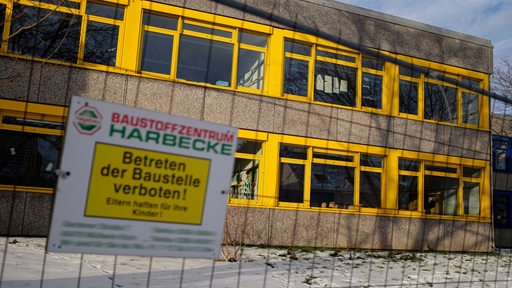 Ein eingezäuntes Schulgebäude mit dem Schild: Betreten der Baustelle verboten.