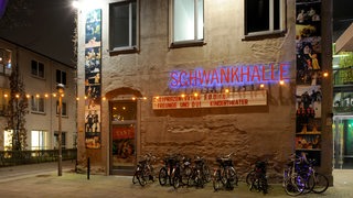 Die beleuchtete Fassade des Kulturzentrums Schwankhalle in Bremen bei Nacht