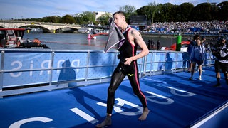 Schwimmer Florian Wellbrock kommt nach dem enttäuschenden Freiwasser-Wettbewerb bei den Olympischen Spielen in Paris aus dem Wasser und trocknet sich im Laufen ab.