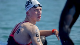 Schwimm-Olympiasieger Florian Wellbrock hockt nach dem enttäuschenden Abschneiden im Freiwasser-Rennen bei der WM in Katar am Steg.