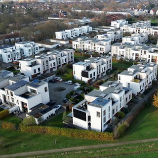 Eine Neubausiedlung mit weißen Häusern ist zu sehen