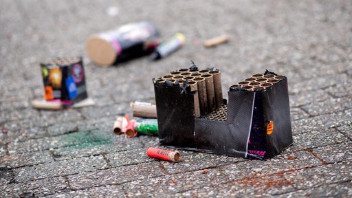 Reste von Feuerwerk aus der Silvesternacht liegt auf einer Straße.