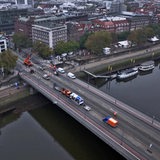 Baufahrzeuge stehen auf einer mehrspurigen Brücke in einer Stadt.