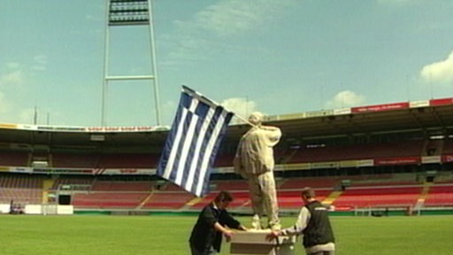 Eine Statue, die eine Griechenlandfahne in der Hand hält, steht im Bremer Weserstadion