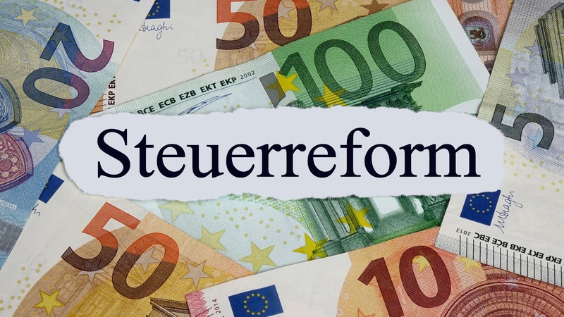 Auf vielen Geldscheinen liegt ein Zettel mit der Aufschrift "Steuerreform".