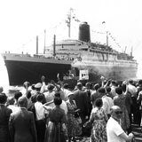 Auf dem Kai stehende Menschen winken dem Schiff hinterher. Pünktlich um zwölf Uhr am 9. Juli 1959 ist der Ozeanriese "Bremen" von Bremerhaven aus zu seiner Jungfernfahrt nach New York ausgelaufen.