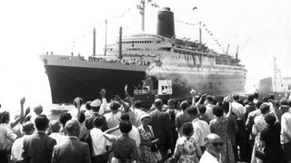 Auf dem Kai stehende Menschen winken dem Schiff hinterher. Pünktlich um zwölf Uhr am 9. Juli 1959 ist der Ozeanriese "Bremen" von Bremerhaven aus zu seiner Jungfernfahrt nach New York ausgelaufen.