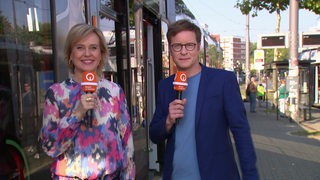 Moderatoren Kirsten Radernmacher und Felix Krömer vor der Straßenbahn