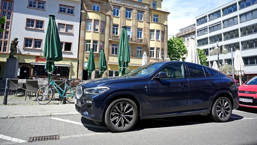 Ein SUV steht auf einem Parkplatz. Die Parkbucht ist zu klein für das Fahrzeug.