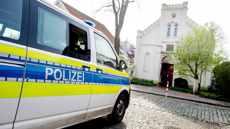 Ein Einsatzfahrzeug der Polizei steht vor der Synagoge im Stadtzentrum in Oldenburg. 