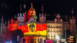 Auf die Fassade des Schweriner Schlosses ist eine Lichtershow projiziert.