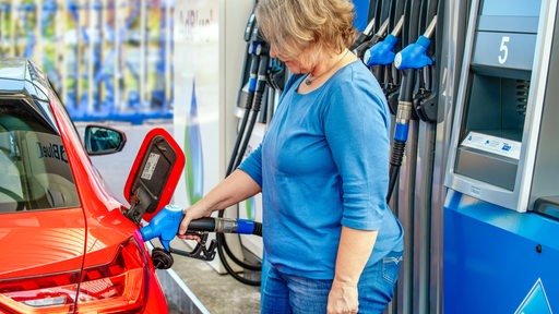 Eine Frau betankt ihr Fahrzeug an einer Tankstelle (Symbolbild)