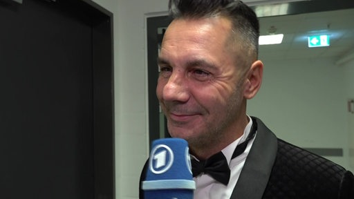 Grün-Gold-Trainer Roberto Albanese strahlt bei einem Interview nach dem Gewinn der Meisterschaft seiner Lateinformation.