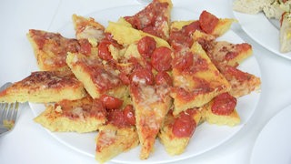 Polenta mit Tomate auf einem Teller.