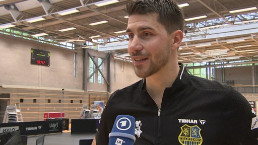 Saarbrückens Tischtennis-Spieler Patrick Franziska steht nach dem Spiel in der Halle beim Interview.