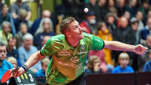 Werders Tischtennis-Profi Mattias Falck konzentriert sich beim Aufschlag auf den hochgeworfenen Ball.