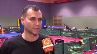 Werders Tischtennis-Trainer Cristian Tamas steht in der Trainingshalle bei einem Interview.