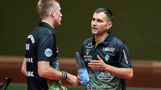 Werders Tischtennis-Trainer Cristian Tamas während einer Auszeit im Gespräch mit Spieler Mattias Falck.