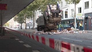 Ein Müllauto wird auf der Straße geleert.